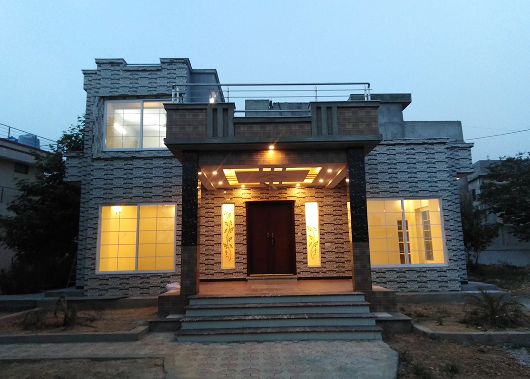 stone textured home with accent lighting by hescon engineering