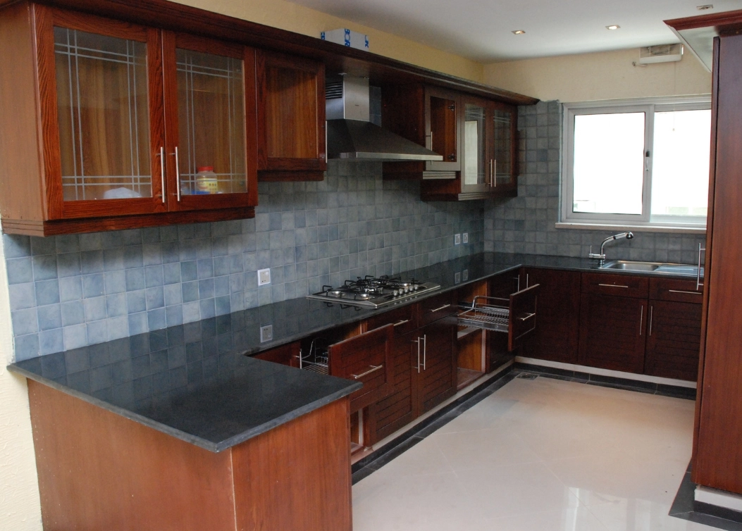 u-shaped kitchen with wooden cabinets and blue tiles by hescone engineering